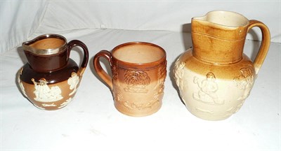 Lot 63 - A stoneware relief moulded mug, a Doulton stoneware jug and a larger example (3)