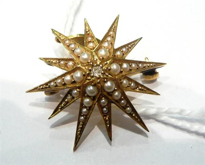 Lot 184 - A diamond and seed pearl set star pendant/brooch, stamped '15CT'