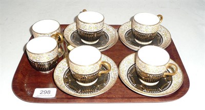 Lot 298 - Royal Worcester six piece black gilt and jewelled cups and saucers and six silver gilt teaspoons