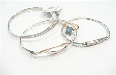 Lot 480 - Three silver bangles, blue topaz ring