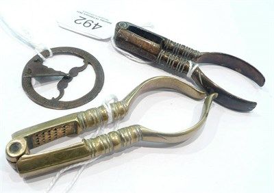 Lot 492 - Two pairs of 18th century brass nut crackers and an miniature brass sundial with folding gnomen