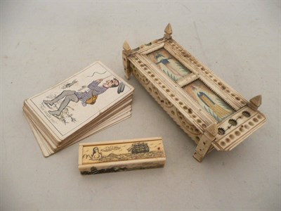 Lot 519 - A Napoleonic prisoner of war work carved bone cribbage board, a miniature set of dominos and a card