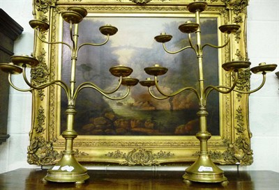 Lot 734 - A pair of brass eight branch ecclesiastical candlesticks