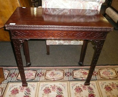 Lot 839 - Mahogany foldover card table with blind fret carved frieze and legs