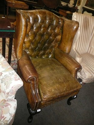 Lot 841 - A George II style green leather button back armchair