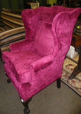 Lot 876 - A wing back chair on claw and ball feet