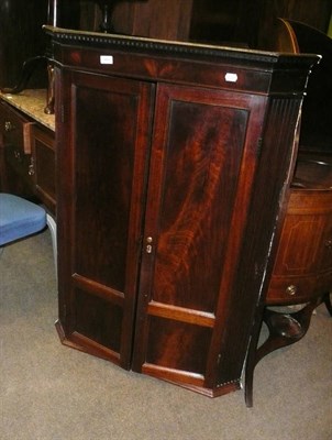 Lot 989 - A George III Mahogany Hanging Corner Cupboard, early 19th century, the dentil cornice above...