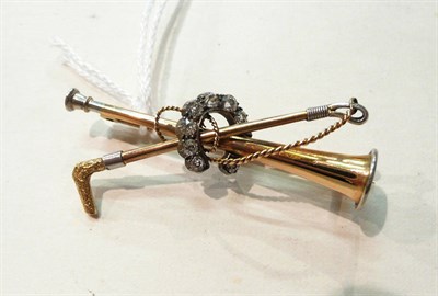 Lot 75 - A diamond set horn and crop horseshoe brooch