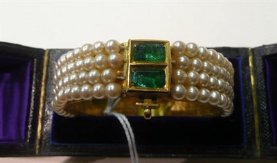 Lot 92 - A four row bangle set with an emerald-like stone, cased