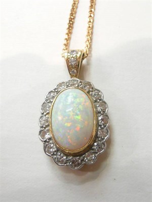 Lot 114 - An opal and diamond cluster pendant on an 18ct gold chain, an oval cabochon opal within a border of