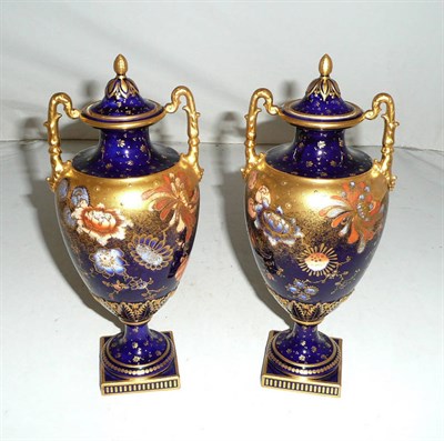 Lot 227 - A pair of Royal Crown Derby blue ground twin-handled urns with gilt decoration