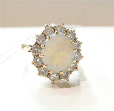 Lot 306 - An 18ct gold opal and diamond cluster ring, oval cabochon opal within a border of round...