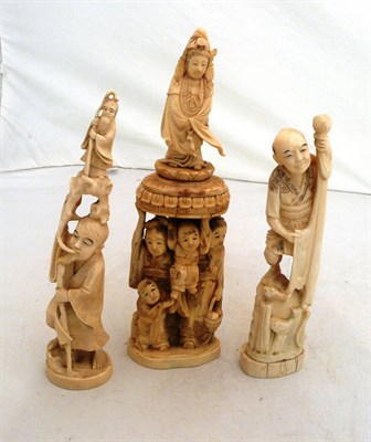 Lot 321 - A Japanese marine ivory group of figures holding a deity above their heads, two marine ivory...