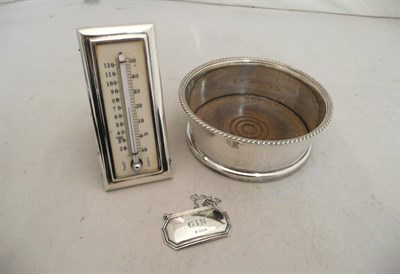 Lot 489 - A silver and ivory desk thermometer, a silver wine coaster and a silver decanter label