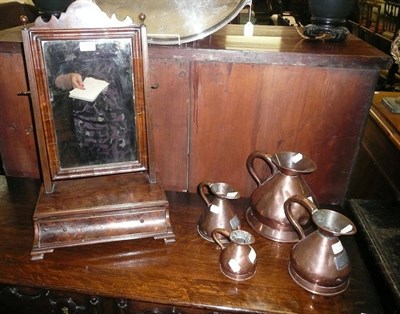 Lot 558 - Walnut veneered toilet mirror and four copper measures