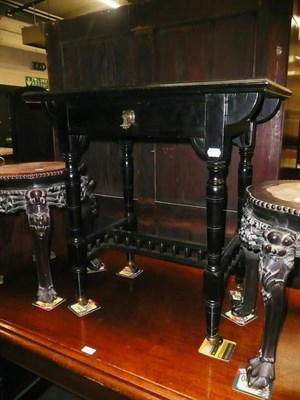 Lot 726 - An ebonised writing table with leather top