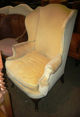 Lot 780 - A wing armchair upholstered in yellow fabric