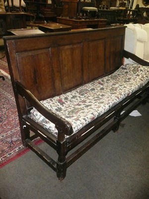 Lot 809 - An 18th century oak settle with strung cushion seat and panelled back