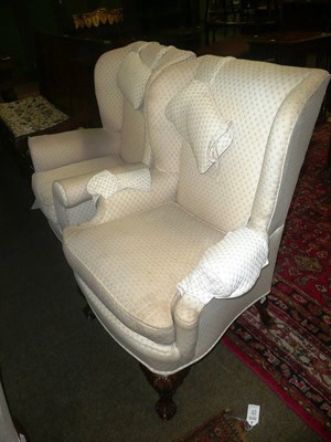 Lot 810 - Pair of wing armchairs in cream brocade on ball and claw feet