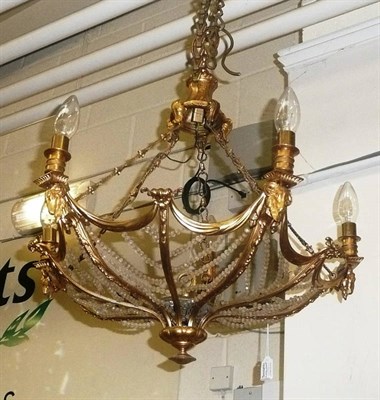 Lot 882 - A gilt metal five light chandelier mounted with rams heads