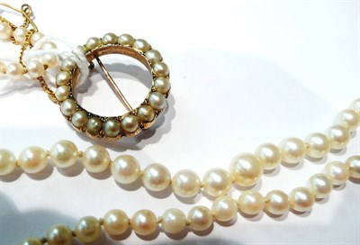 Lot 98 - A cultured pearl necklace and a circular pearl set brooch