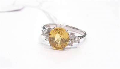 Lot 277 - An 18ct white gold yellow sapphire and diamond ring