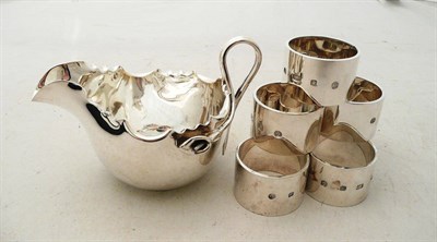 Lot 303 - Six silver napkin rings and silver sauce boat, 20 oz