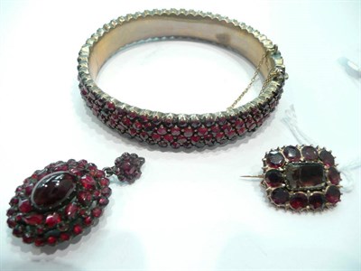 Lot 306 - A foil backed garnet brooch, a pendant and a bangle, (all items a.f.) and three loose stones