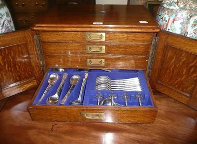 Lot 434 - An extensive oak cased canteen of plated cutlery, contained in four pull out drawers with brass...