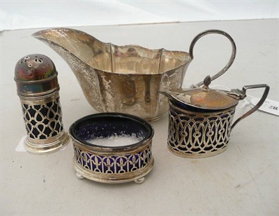 Lot 444 - Three piece pierced silver condiment set with blue glass liners and a silver sauce boat (4)