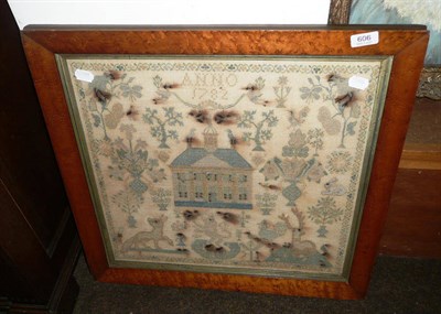 Lot 606 - A maple framed sampler with a central house decorated with birds, animals and flowers, dated...