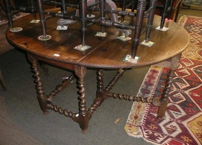 Lot 670 - An oak gateleg dining table