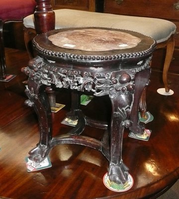 Lot 713 - Oriental carved hardwood occasional table, the circular top inset with red marble, raised on carved