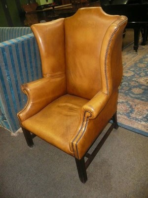 Lot 754 - Leather upholstered wing armchair