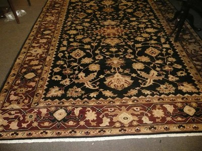 Lot 757 - Large brown and rust-coloured rug with black border