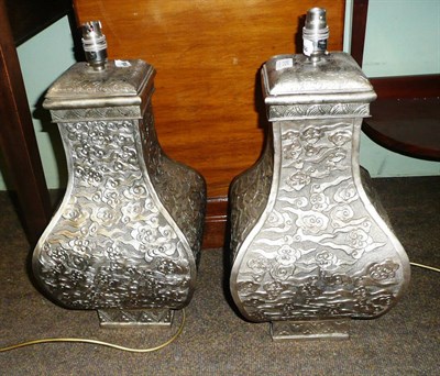 Lot 819 - A pair of Chinese style white metal decorative table lamps