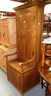 Lot 1210 - A small oak hall settle with a cupboard to the back