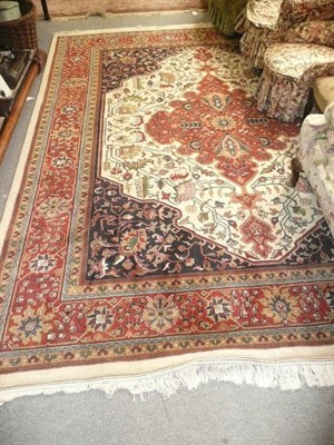 Lot 1224 - An Indian carpet of Heriz design, the ivory field of angular vines around a brick red medallion...