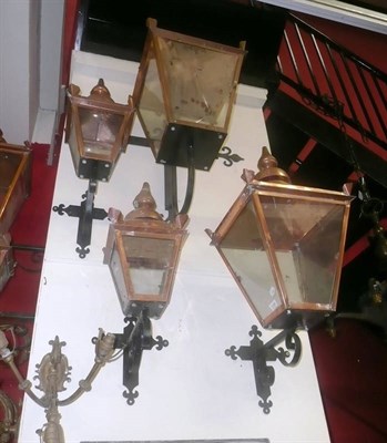 Lot 1284 - A pair of large copper framed lanterns and a smaller pair, all on wrought iron brackets