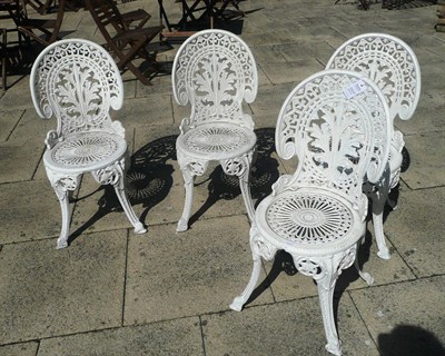 Lot 1311 - Set of four white painted cast iron garden chairs