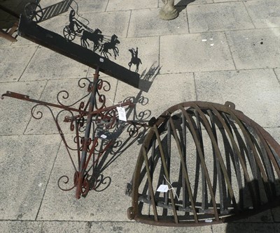 Lot 1323 - Wrought iron weather vane top with a coach and horses mount (a.f.) and two hay racks (3)