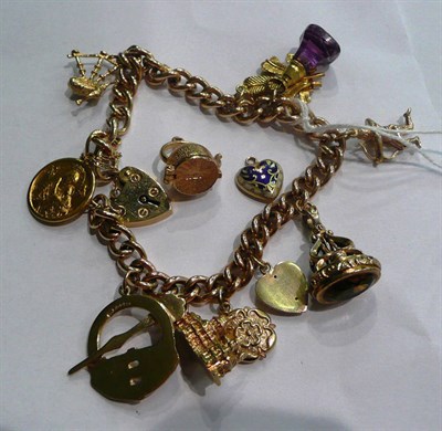 Lot 57 - A charm bracelet hung with ten charms and two loose