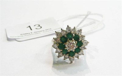 Lot 13 - A diamond and emerald cluster ring, a round brilliant cut diamond within a border of emeralds,...