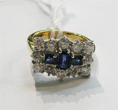 Lot 15 - An 18ct gold sapphire and diamond cluster ring, a trio of step cut sapphires within a border of...