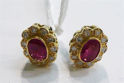 Lot 16 - A pair of ruby and diamond cluster stud earrings, the oval cut rubies in a rubbed over setting...