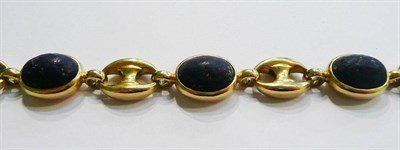Lot 27 - A lapis lazuli bracelet, cabochon lapis lazuli spaced by anchor links, length 19.2cm