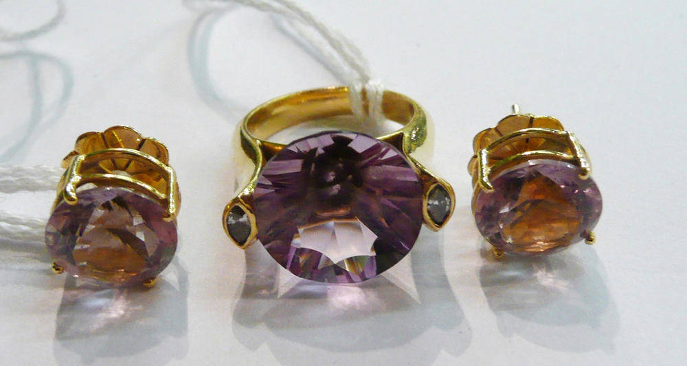 Lot 38 - An amethyst and diamond ring, a round cut amethyst flanked by a marquise cut diamond on each...