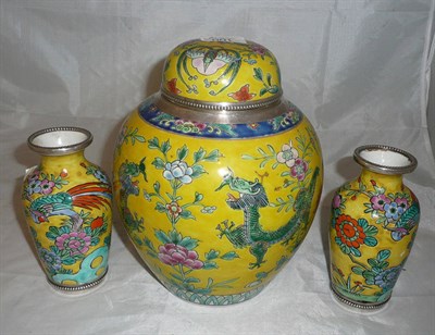 Lot 100 - A garniture of three white metal mounted oriental vases and ginger jar