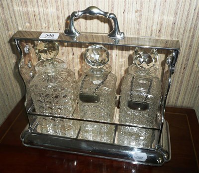 Lot 346 - Three bottle tantalus in plated stand