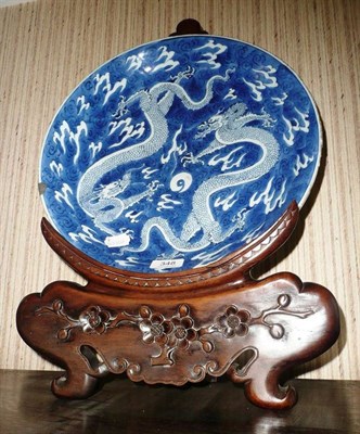 Lot 348 - Chinese blue and white porcelain dragon dish, Kangxi, on carved hardwood stand